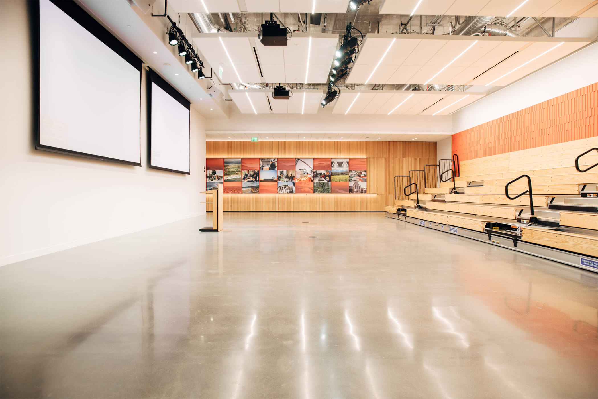 Large empty room with podium and stadium seating on one wall.