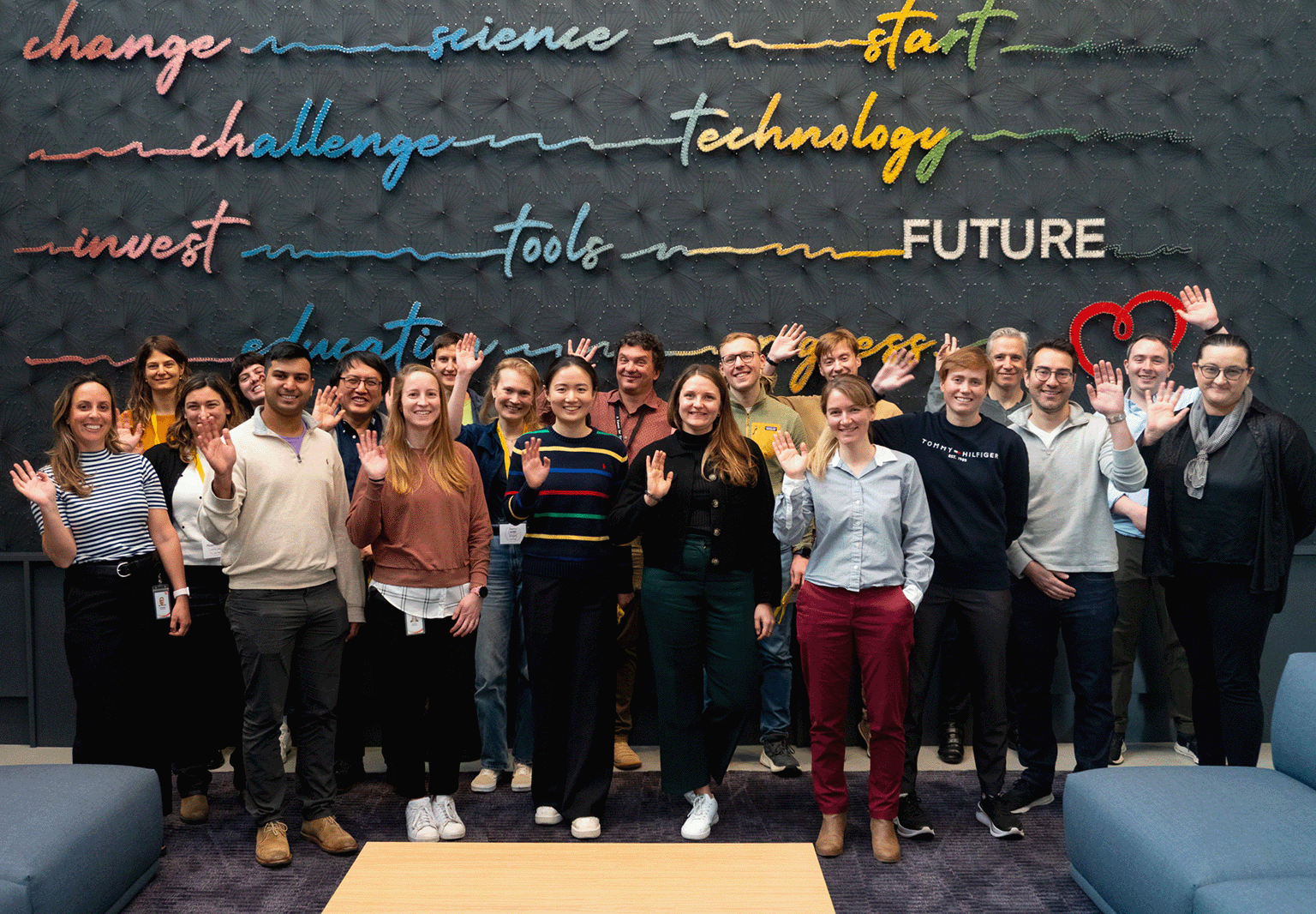 Participants of the Benchmarking and Evaluating Single-Cell Models Jamboree stand and wave in front of the Letter to Max art installation at the CZI headquarters in Redwood City, CA.